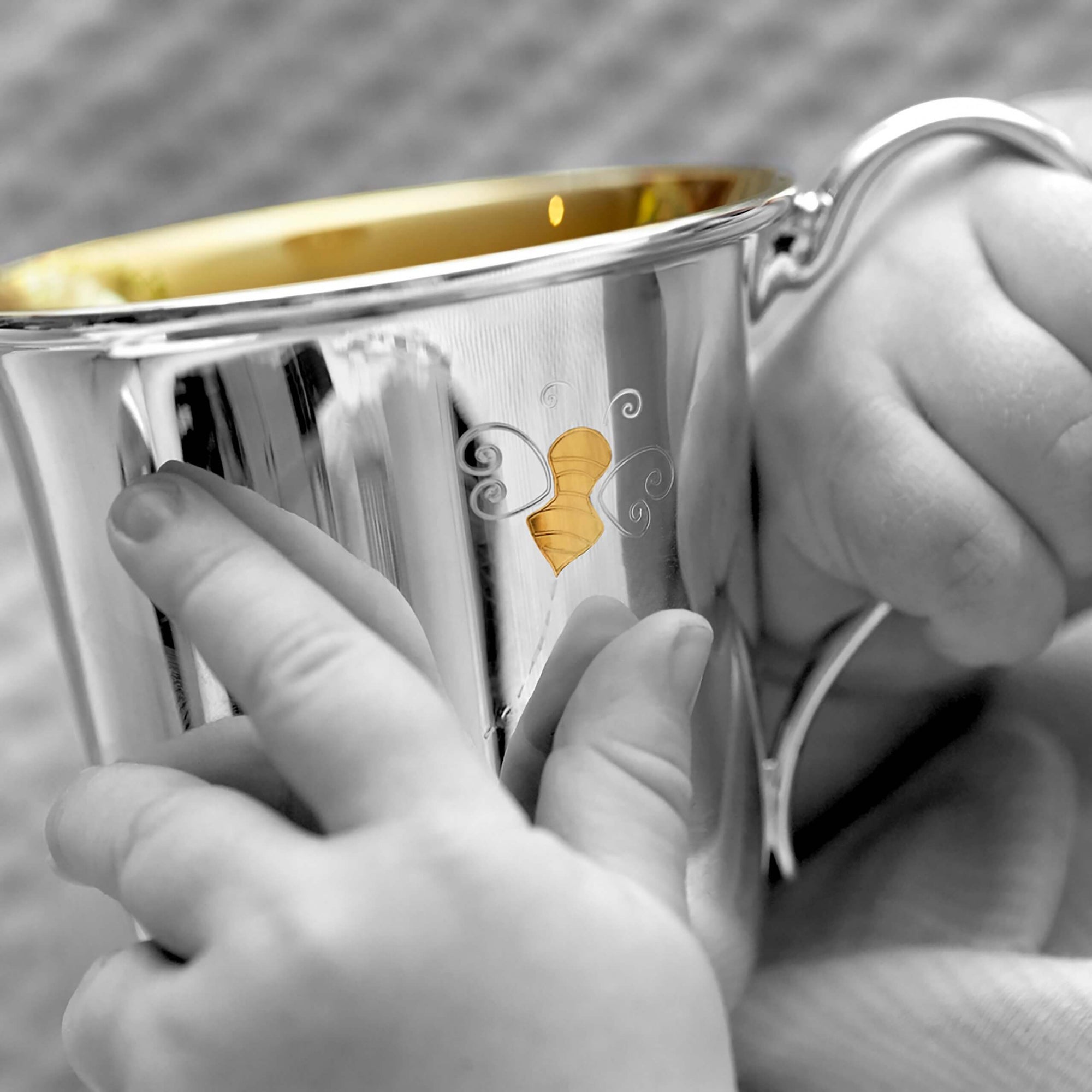 Garrard Christening New Baby Gift Baby Bee collection Sterling Silver Cup 2017564 held by a Baby